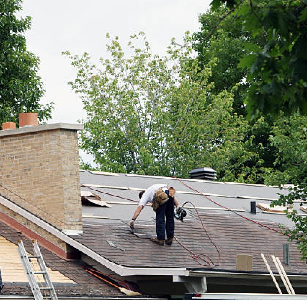 Men installing a new roof on a house. Professional roofing company serving residential customers in Hays County, TX